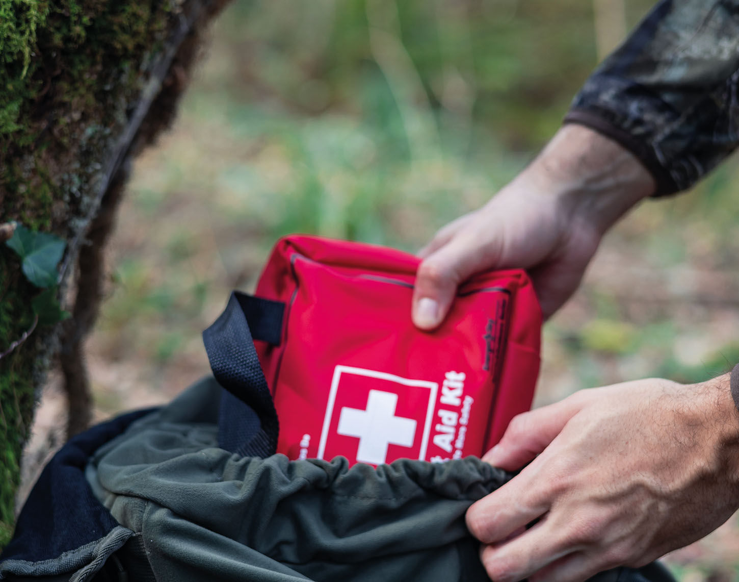 Close-up van ehbo-tasje die in rugzak wordt gestopt