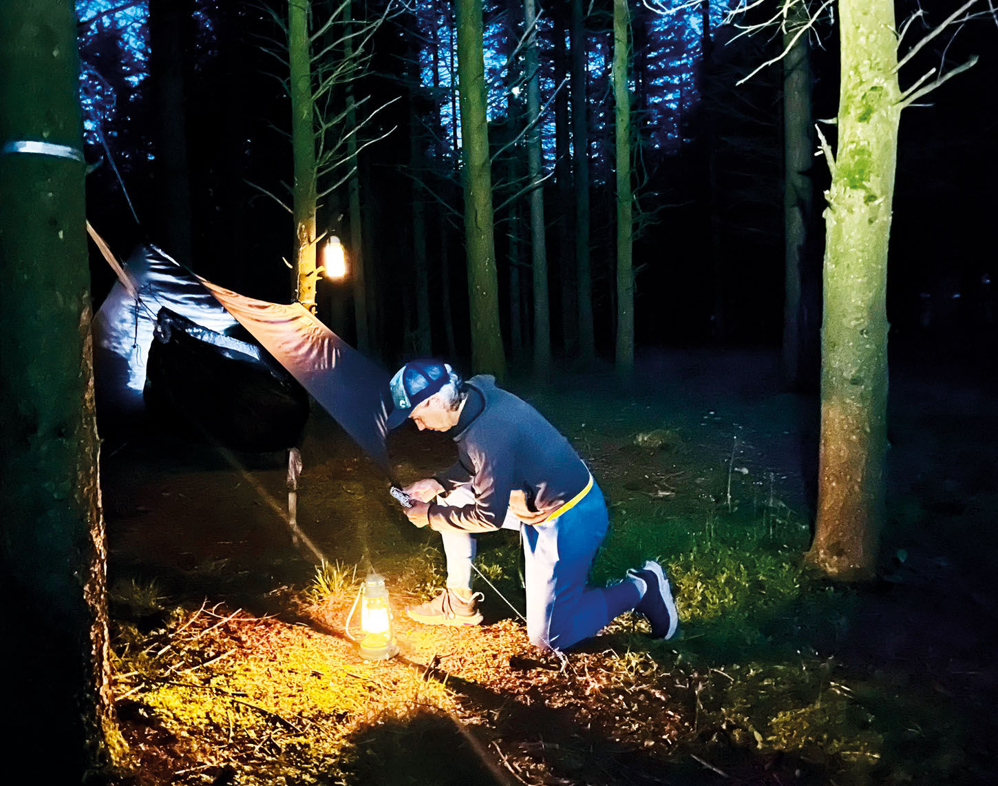 Man bij lantaarnlicht in het bos