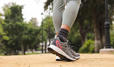Deels benen met sportieve schoenen in bosrijke omgeving