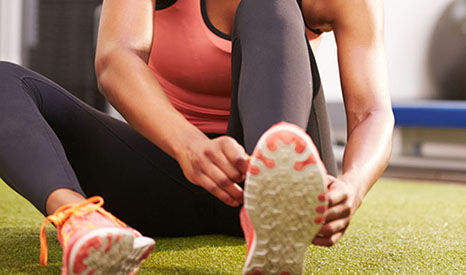 Sportieve vrouw zittend haar sportschoenen aan het strikken
