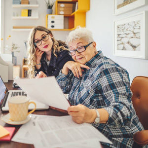 2 Dames achter laptop en bureau met papieren